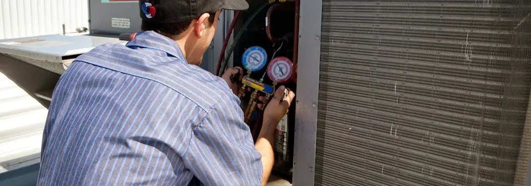 HVAC technician servicing a condenser unit in Hanover Park