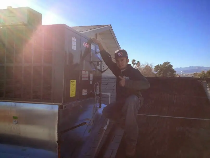 HVAC technician performing AC Tune-Up on a rooftop unit in Hanover Park